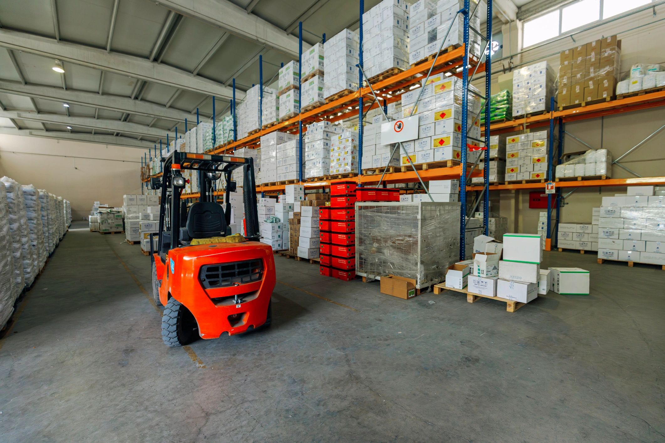 Modern warehouse aisle with organized pallets and logistics equipment